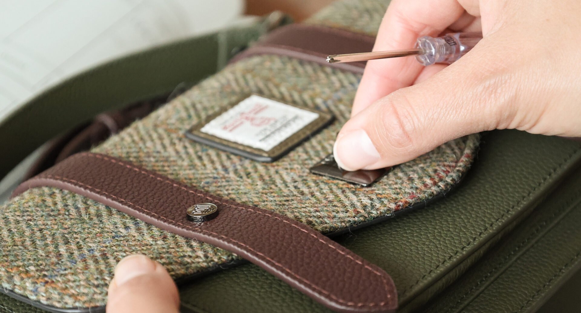 Close-up of a person making a tweed handbag.