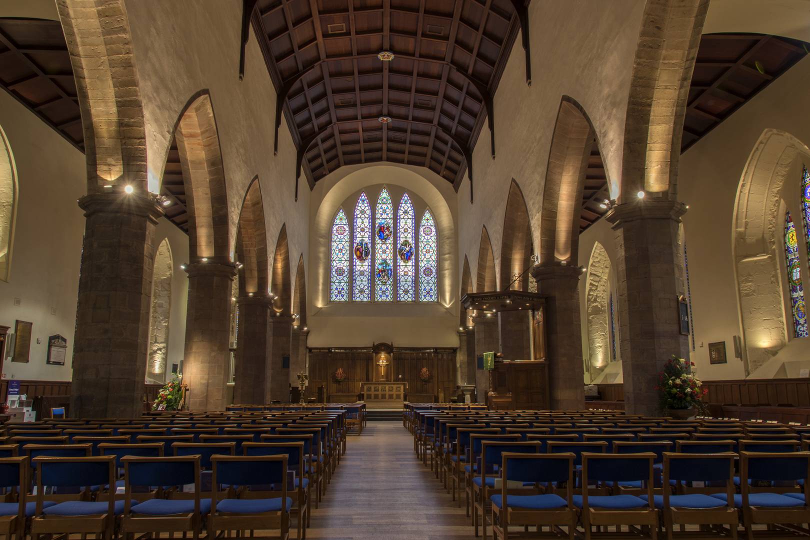 A view of interior of the Kirk, facing the stain glass window at the East End, rows of chairs facing the Chancel.