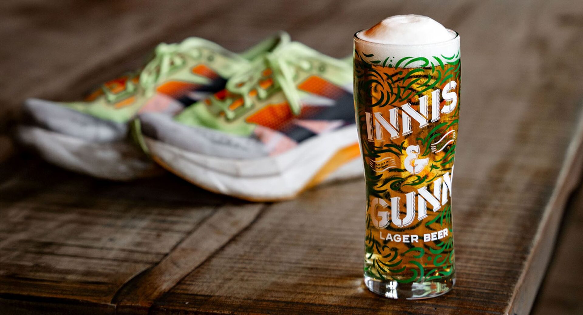 A pint of beer, with a pair of trainers in the background.