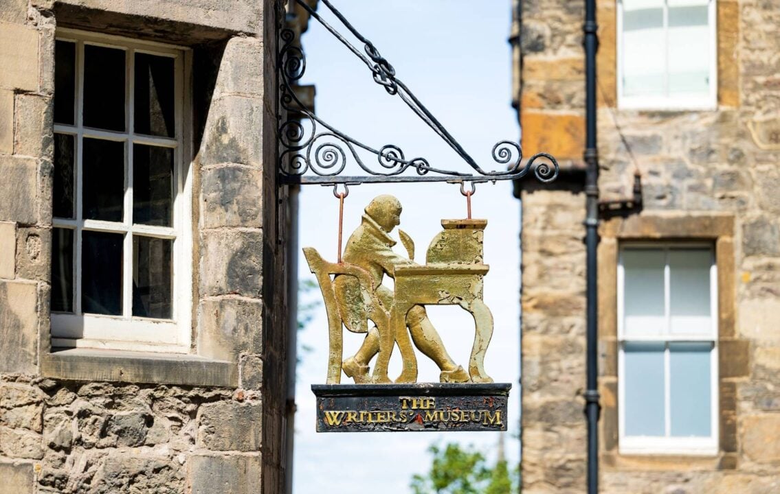 Writer's Museum sign showing someone writing with a quill at a desk