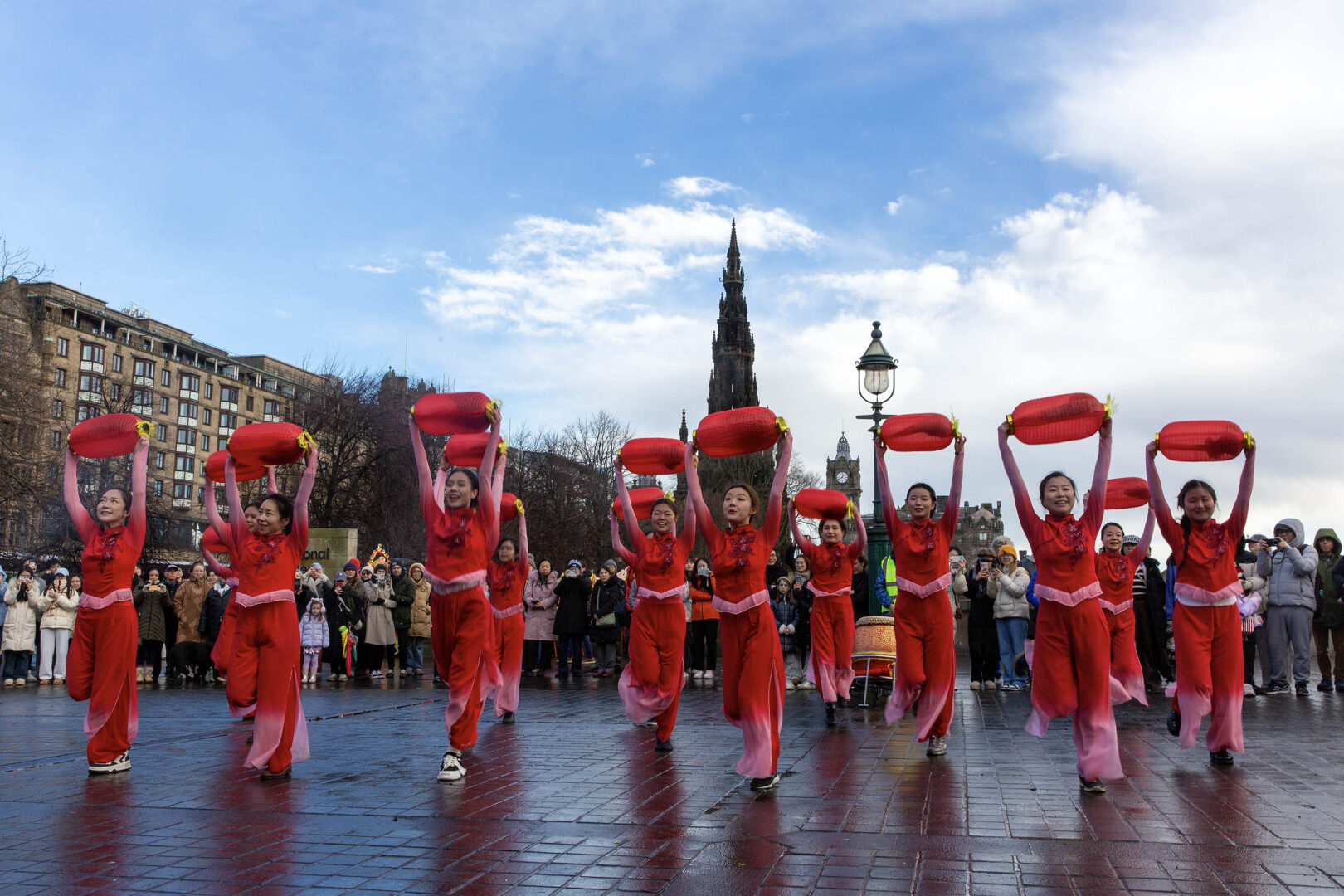 A shot from the Mound with the Scott Monument in the background, showing women in red Chinese costumes dancing