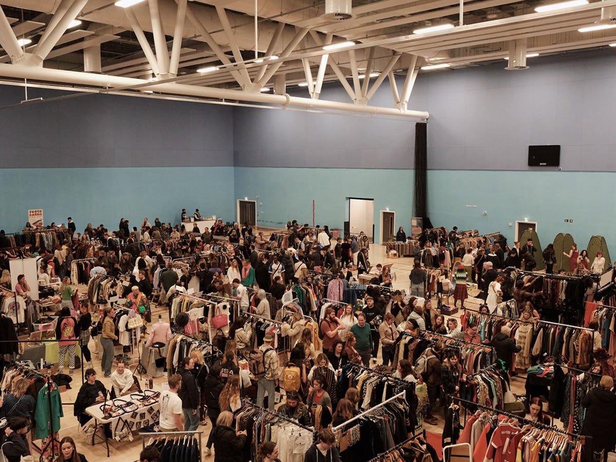 People browsing clothing stalls in a hall