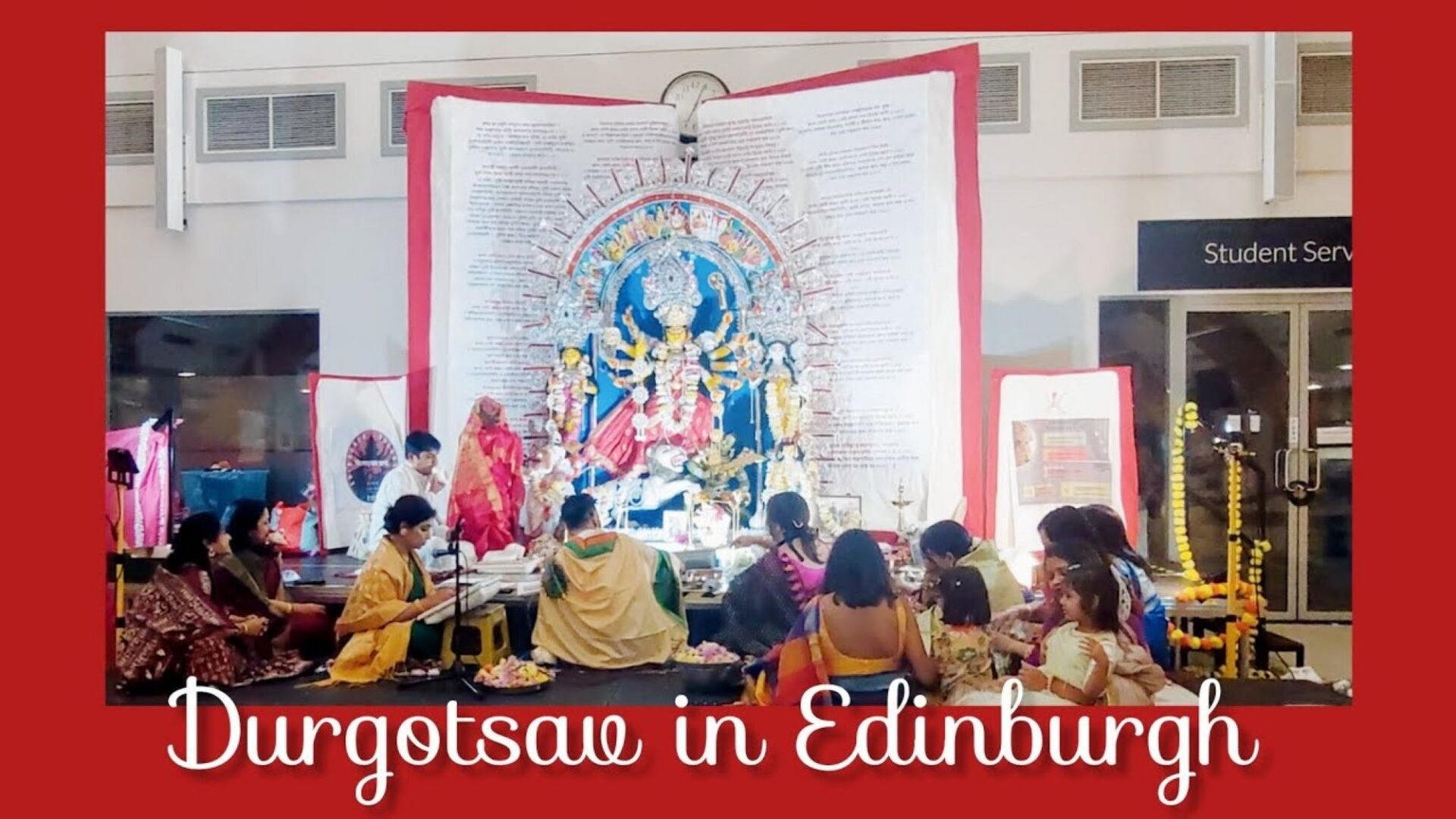 A group of people seated around a large ornately decorated book.