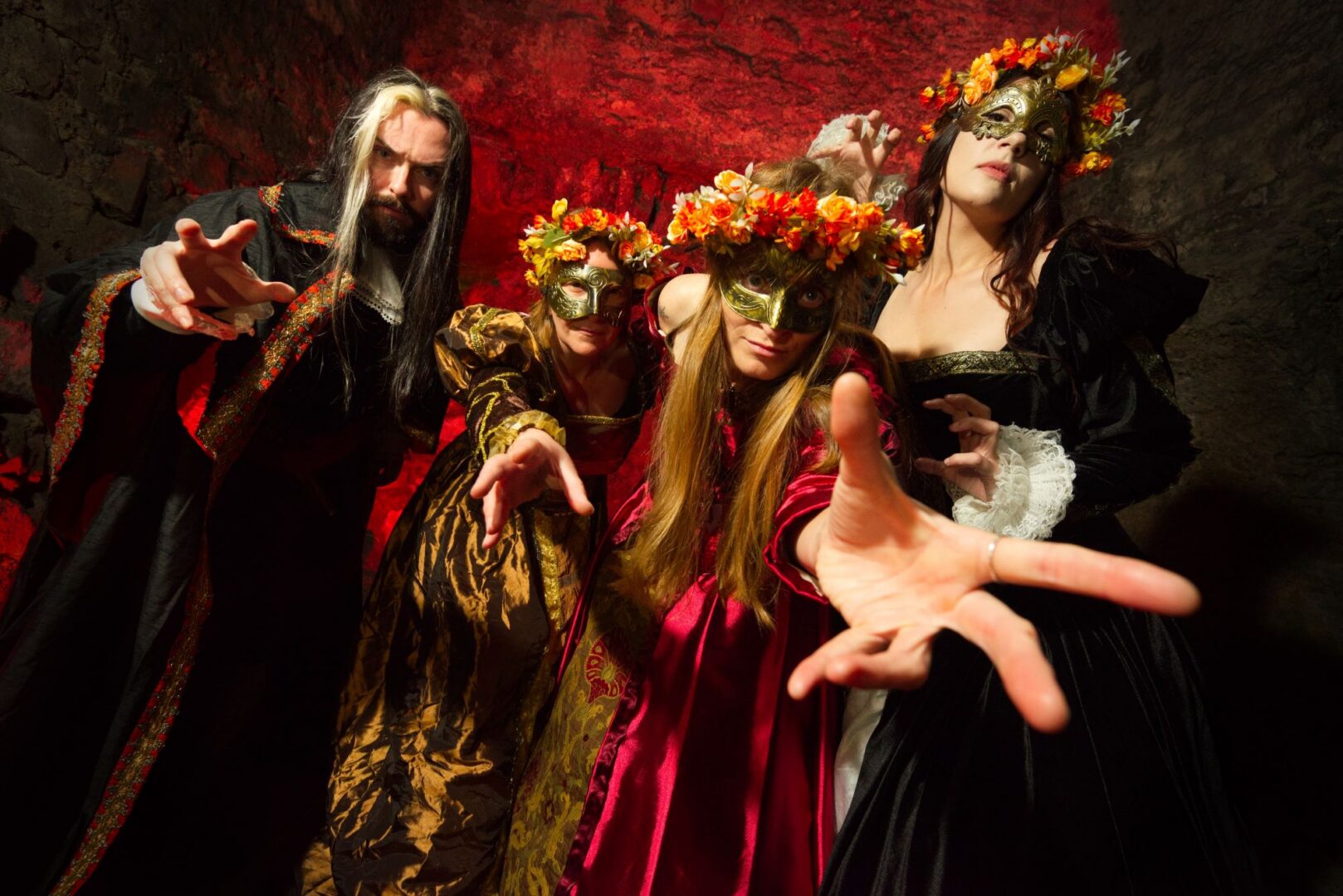 A group of people wearing elaborate dress, including masks and flowery headdresses.