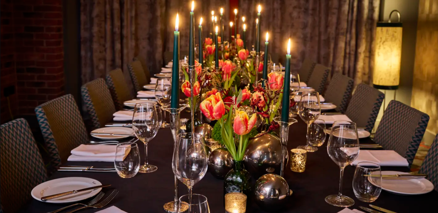 Candle lit long dining table with flowers