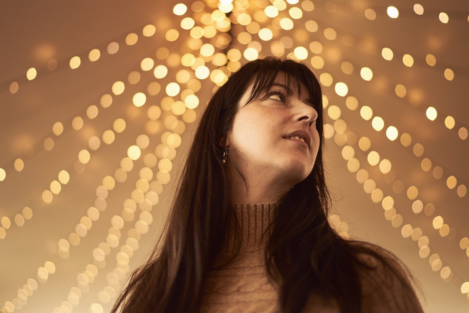 Lady standing under festive lights.