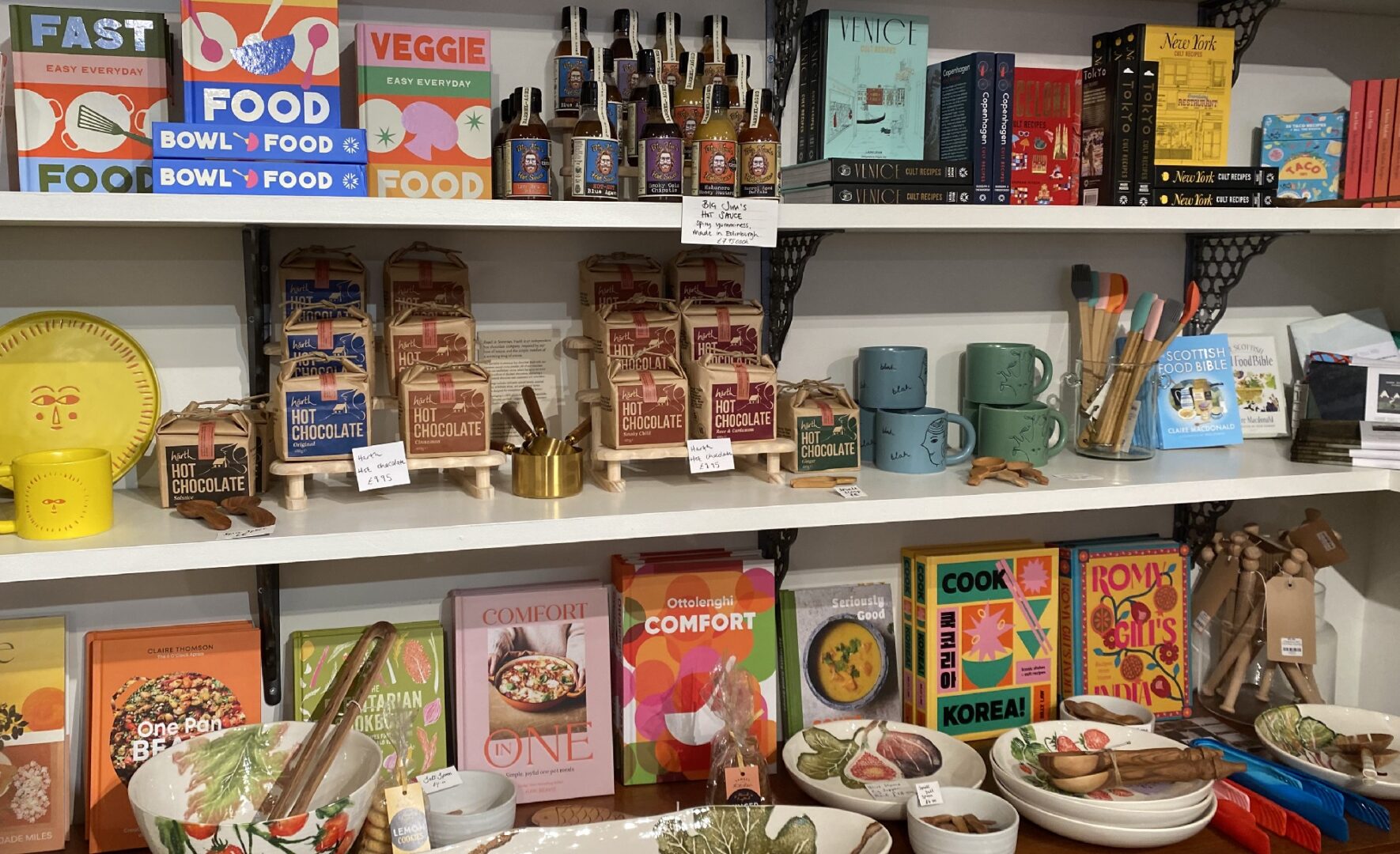 Interior of Curiouser with range of cooking books, Hot chocolates, mugs and plates.