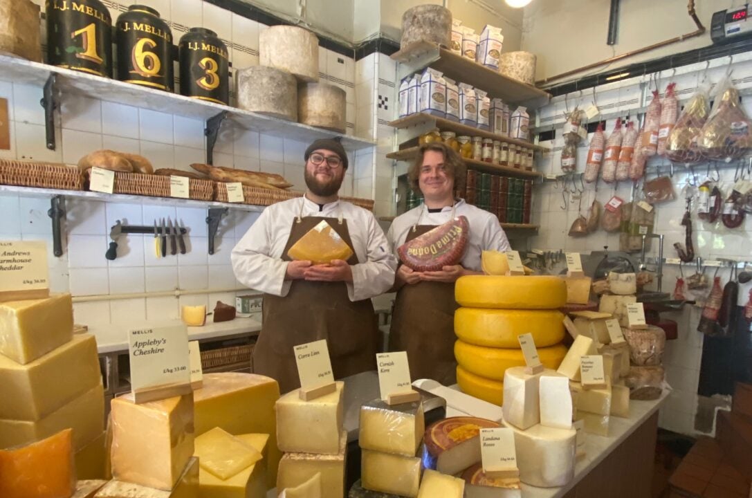 I.J. Mellis staff holding produce behind Cheese counter landscape