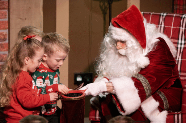 3 young children visiting Santa Claus.