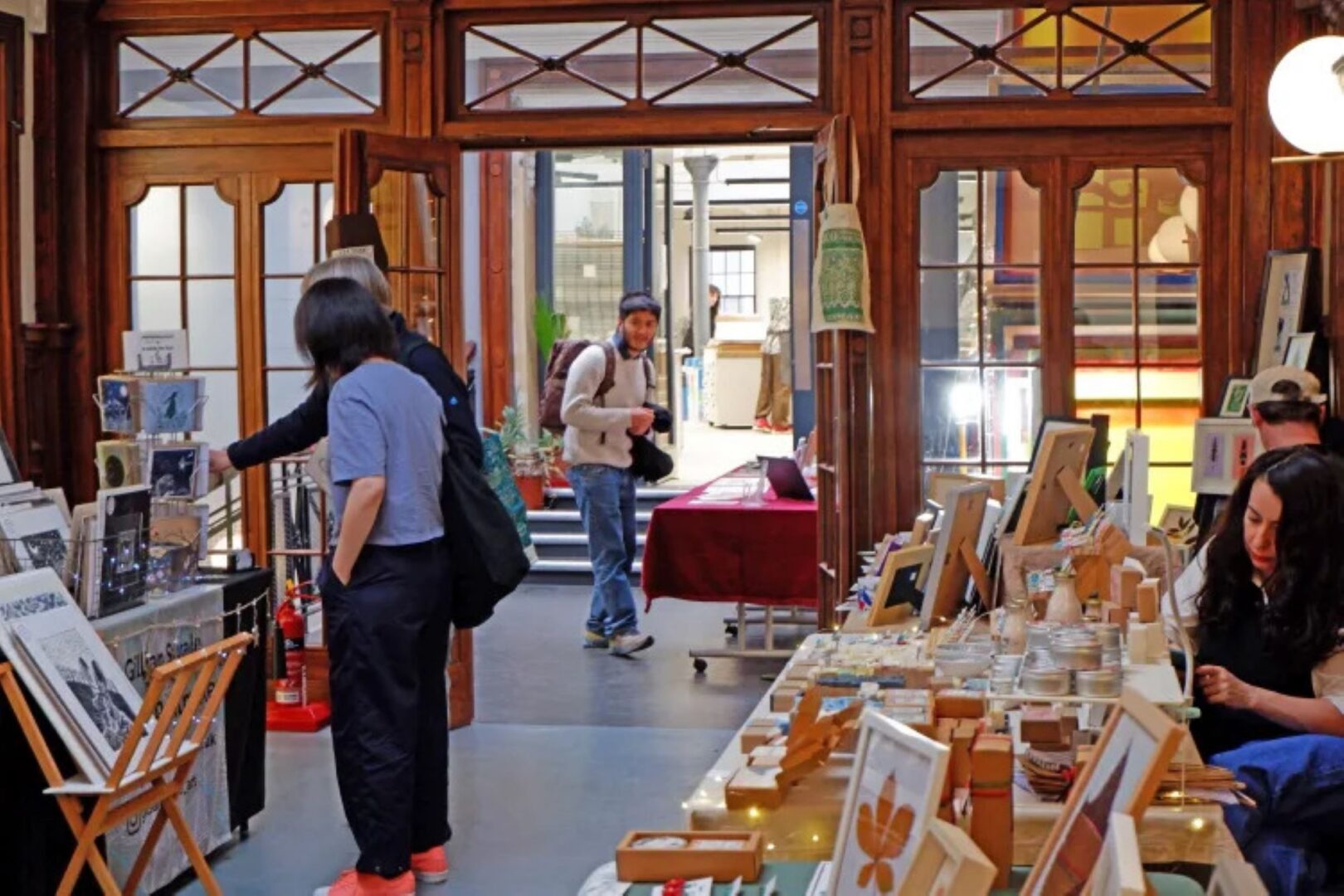 A room full of stalls, with people browsing.
