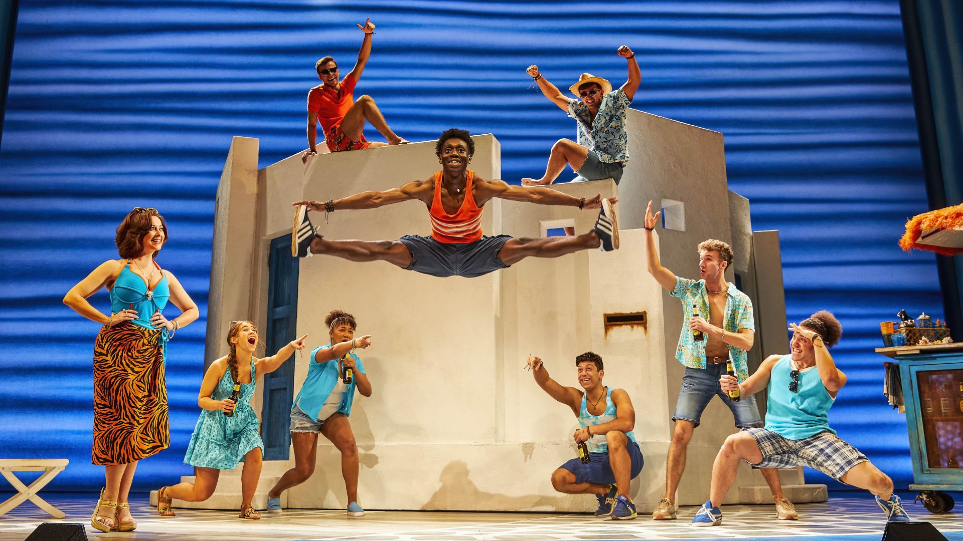 A group of people on stage, all wearing summer clothing.