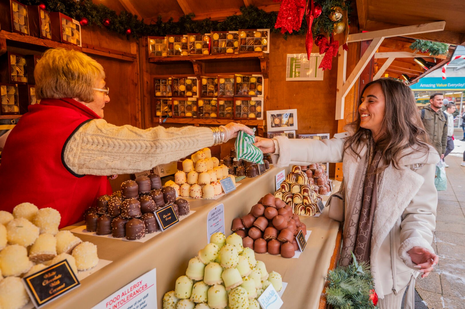 Woman purchasing food at a Christmas market stall