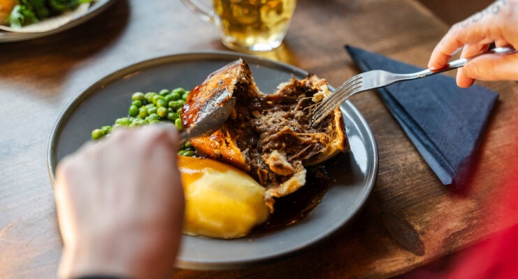 Hands using cutlery to cut into a pie at Johns Coffee House andTavern.