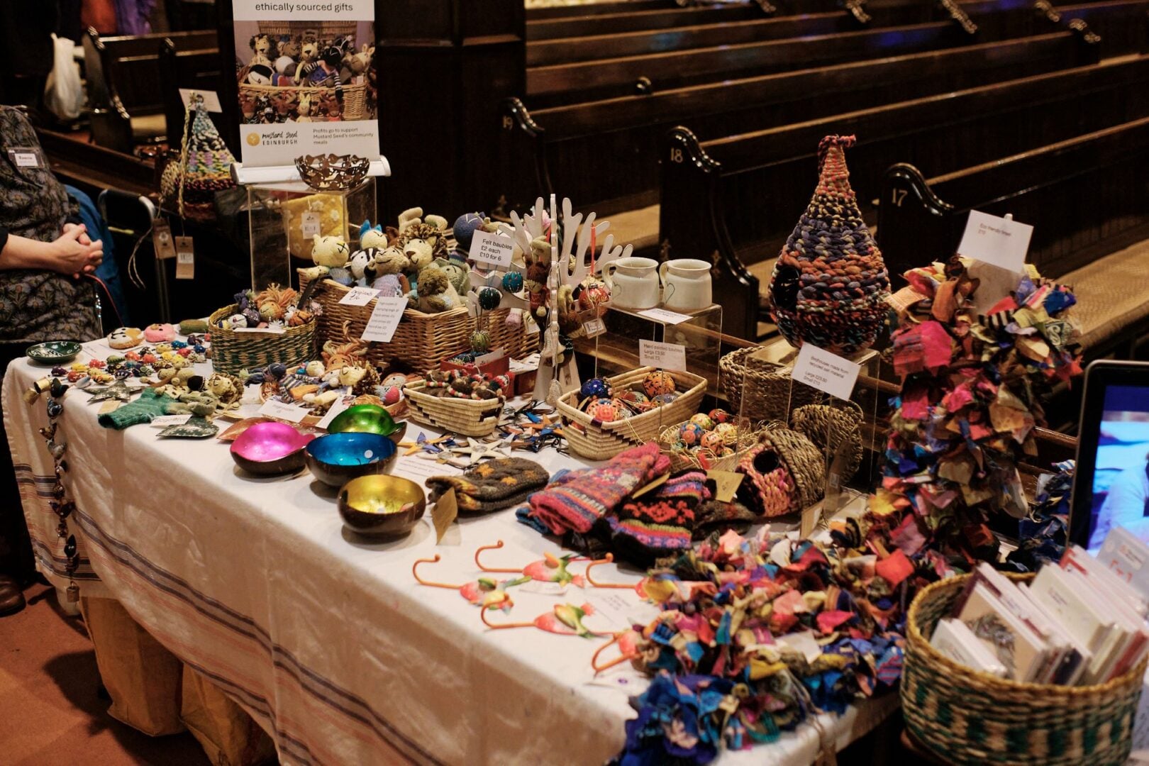 A table of handmade items, including hats and gloves.