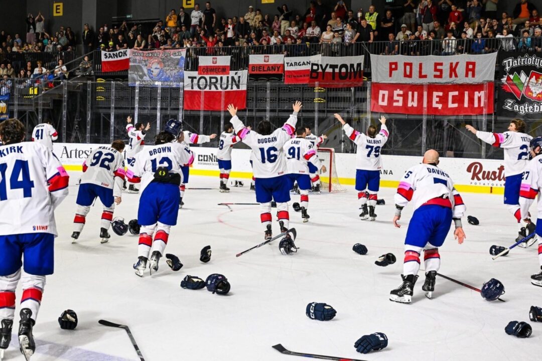 A team of ice hockey players, wearing skates, on a ice rink.
