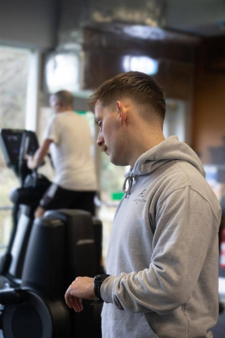 Personal trainer in gym running training session with client.