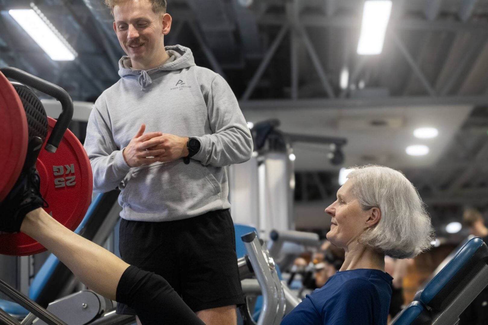 Personal trainer in gym running training session with client.
