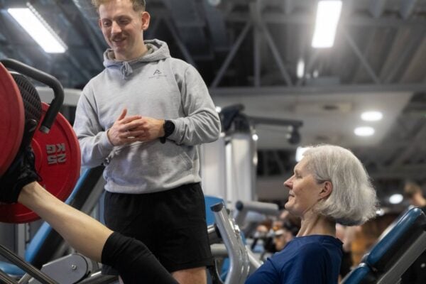 Personal trainer in gym running training session with client.