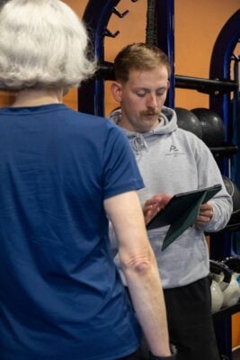 Personal trainer in gym running training session with client.