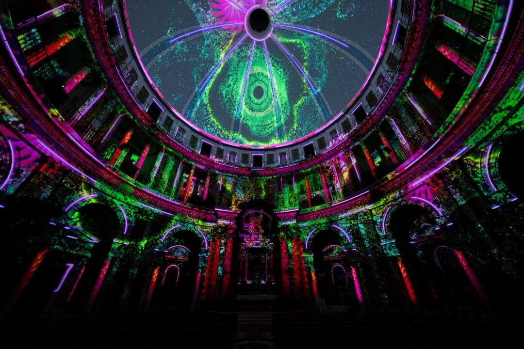 Close-up of a vaulted ceiling illuminated by different coloured lights.