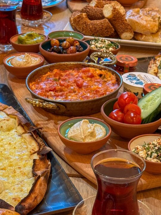 A traditional Turkish breakfast board for two, served with artisan bread, Turkish tea, and Turkish pide (Turkish pizza)