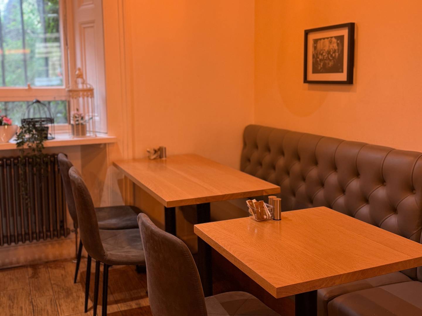 A modern, minimalist space inspired by Turkish heritage, with curated photographs and comfortable booth seating.