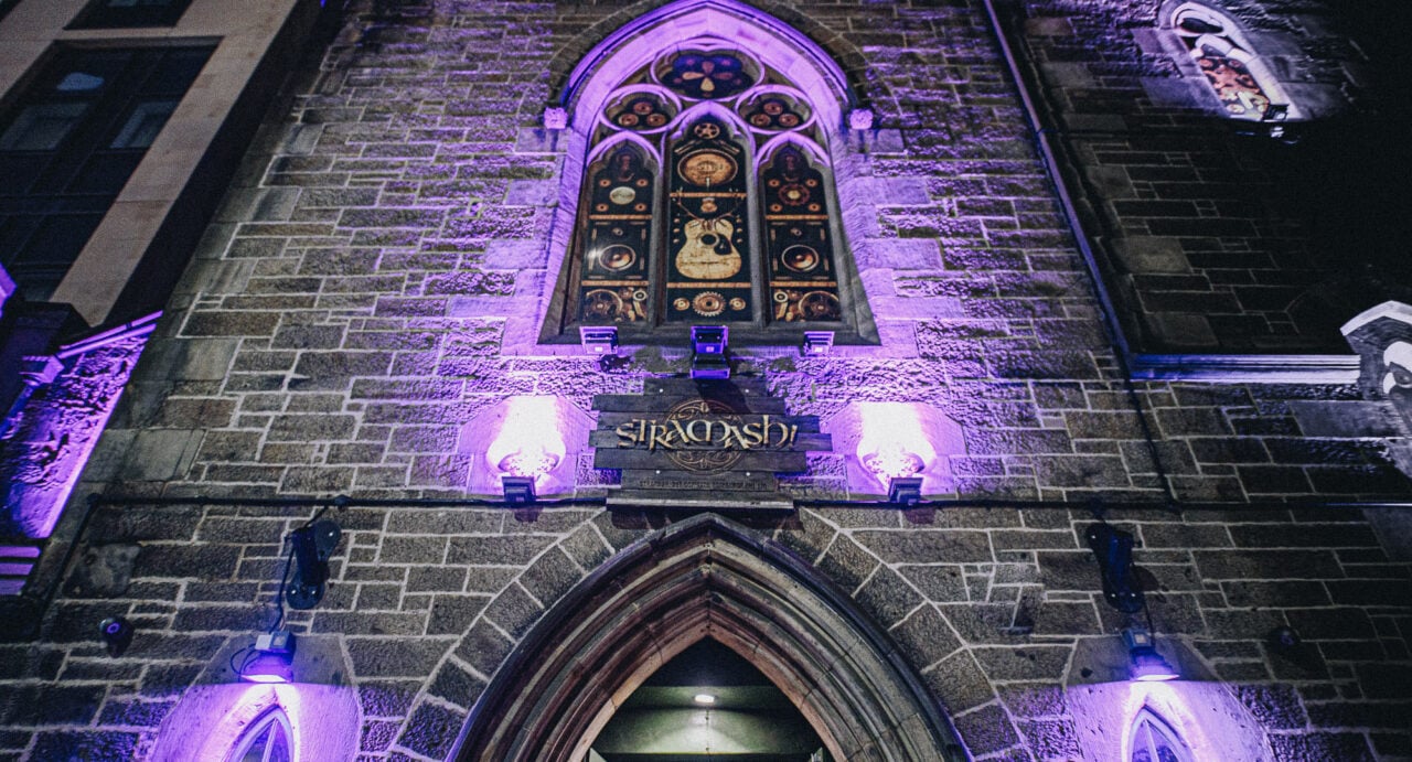 Looking up at the stained glass window of a church building.