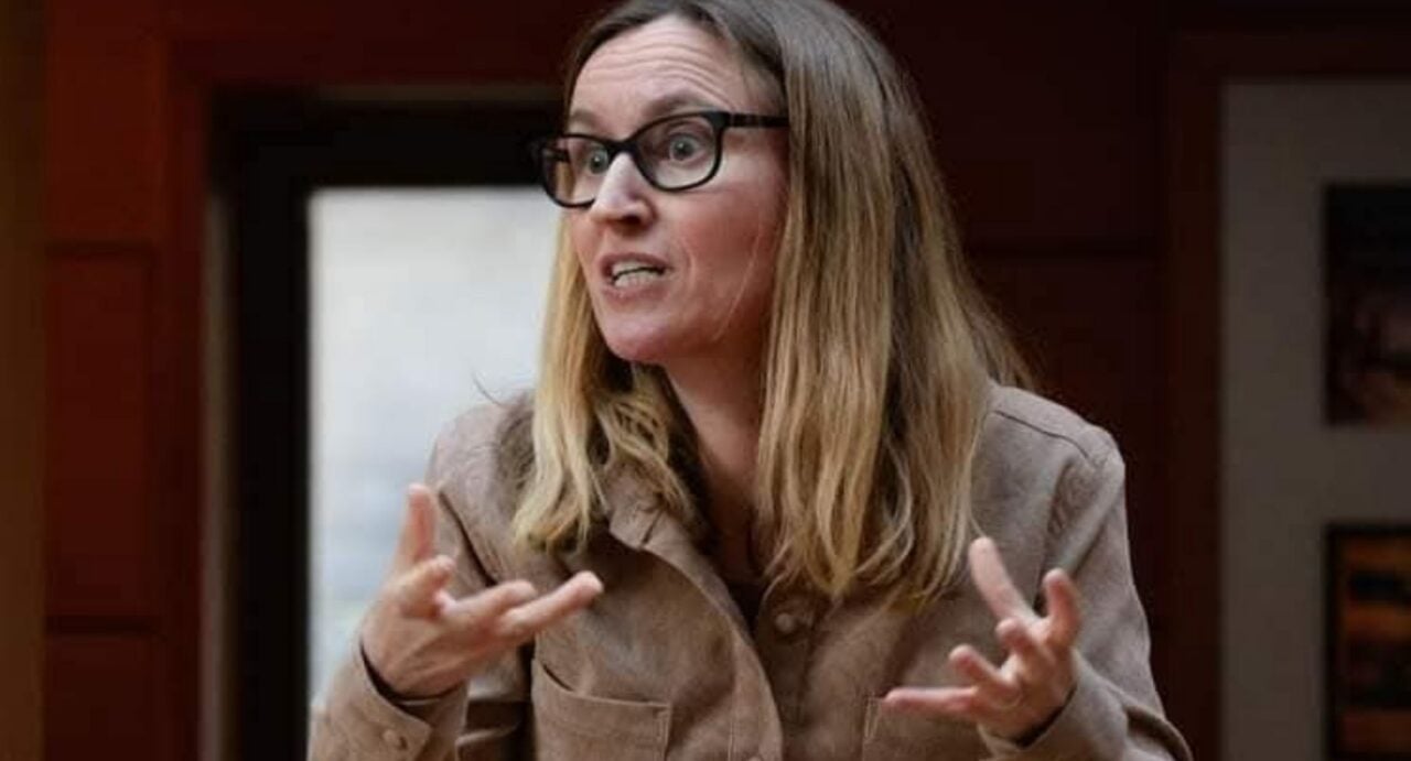 Close-up of woman talking, and gesturing with her hands.