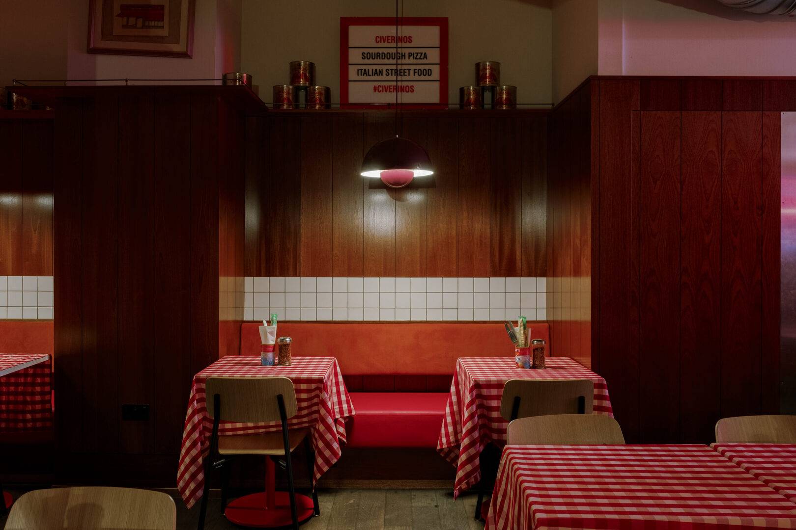 set of two tables on bnech with red checked table cloths and two chairs,© Civerinos