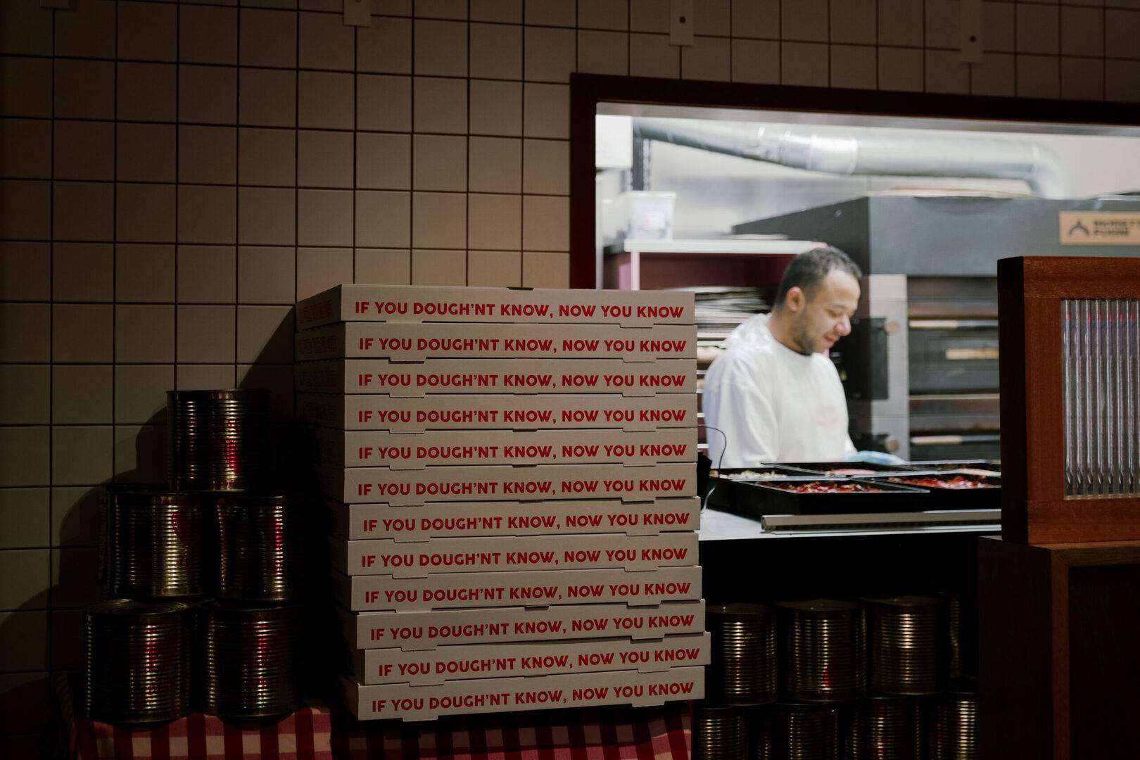 stack of Civerinos takeaway pizza boxes next to kitchen hole in the wall,© Civerinos