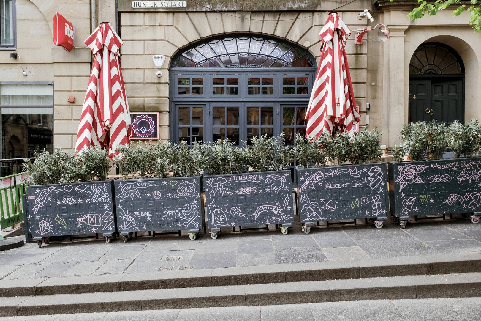the street view of Civerinos Hunter Square with plants and umbrellas outside,© Civerinos