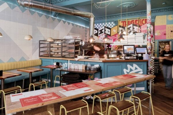 inside civerinos forrest road - long table and stools infront of colourful kitchen area,© Civerinos