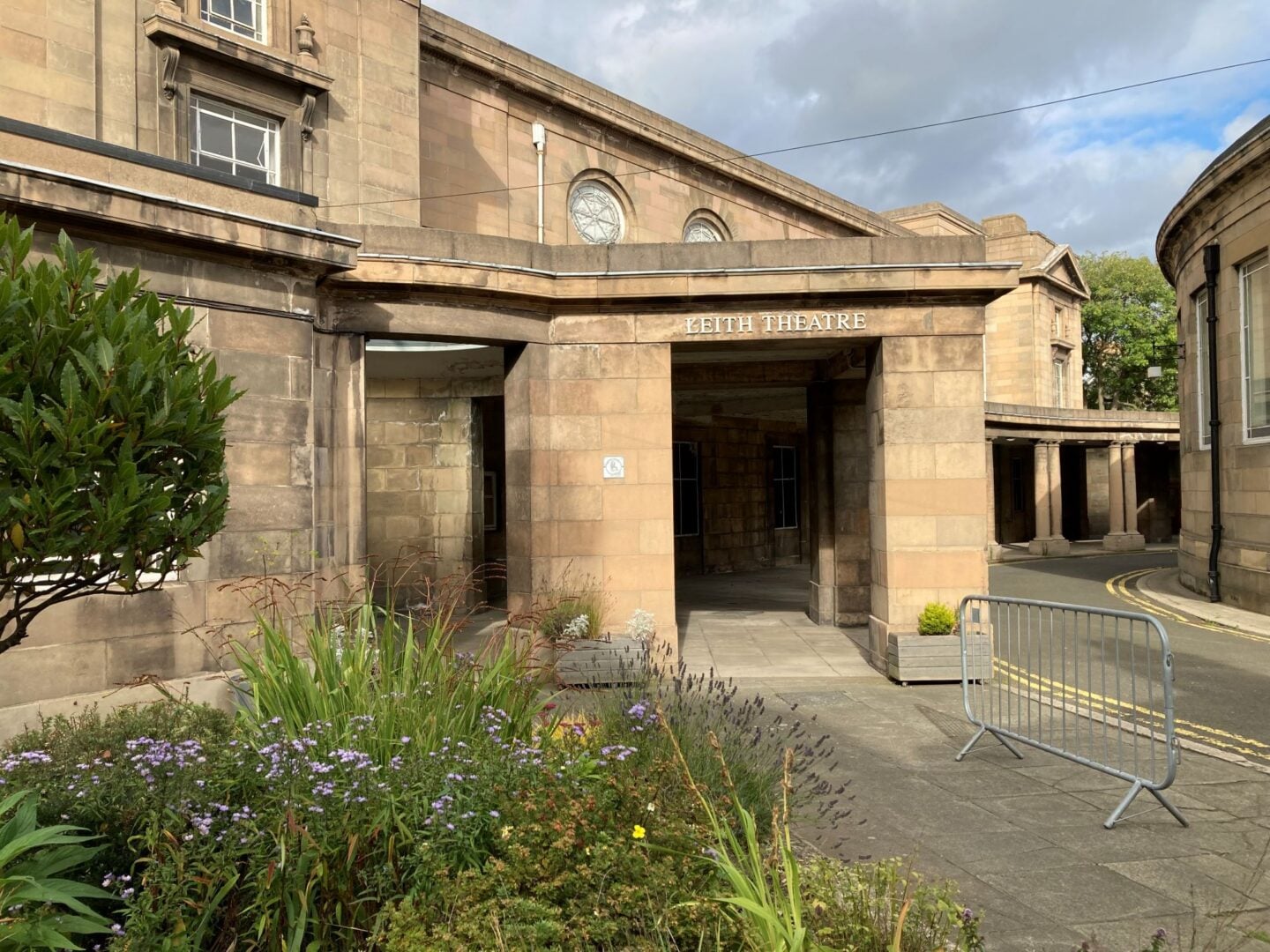 Exterior of a 2-floor sandstone building.