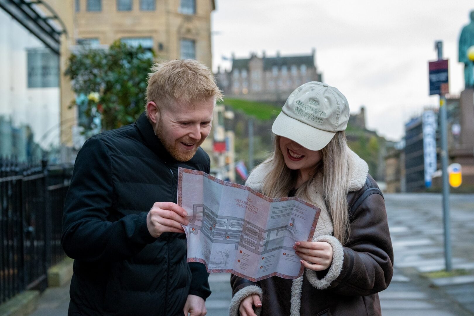 A couple holding a map that has details of bars on map for margarita mile