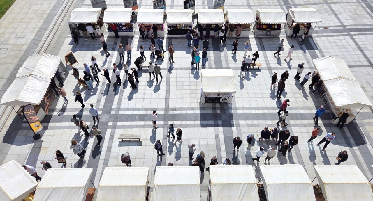 Overhead view of a busy outdoor market with stalls.