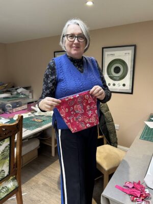 Lady holding up material at Joppa Sewing School