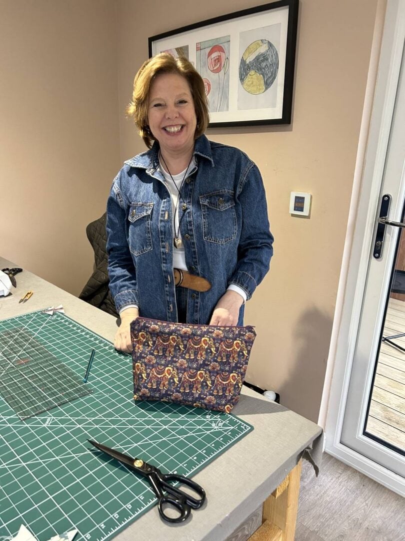 Lady showing a bag made at Joppa Sewing School