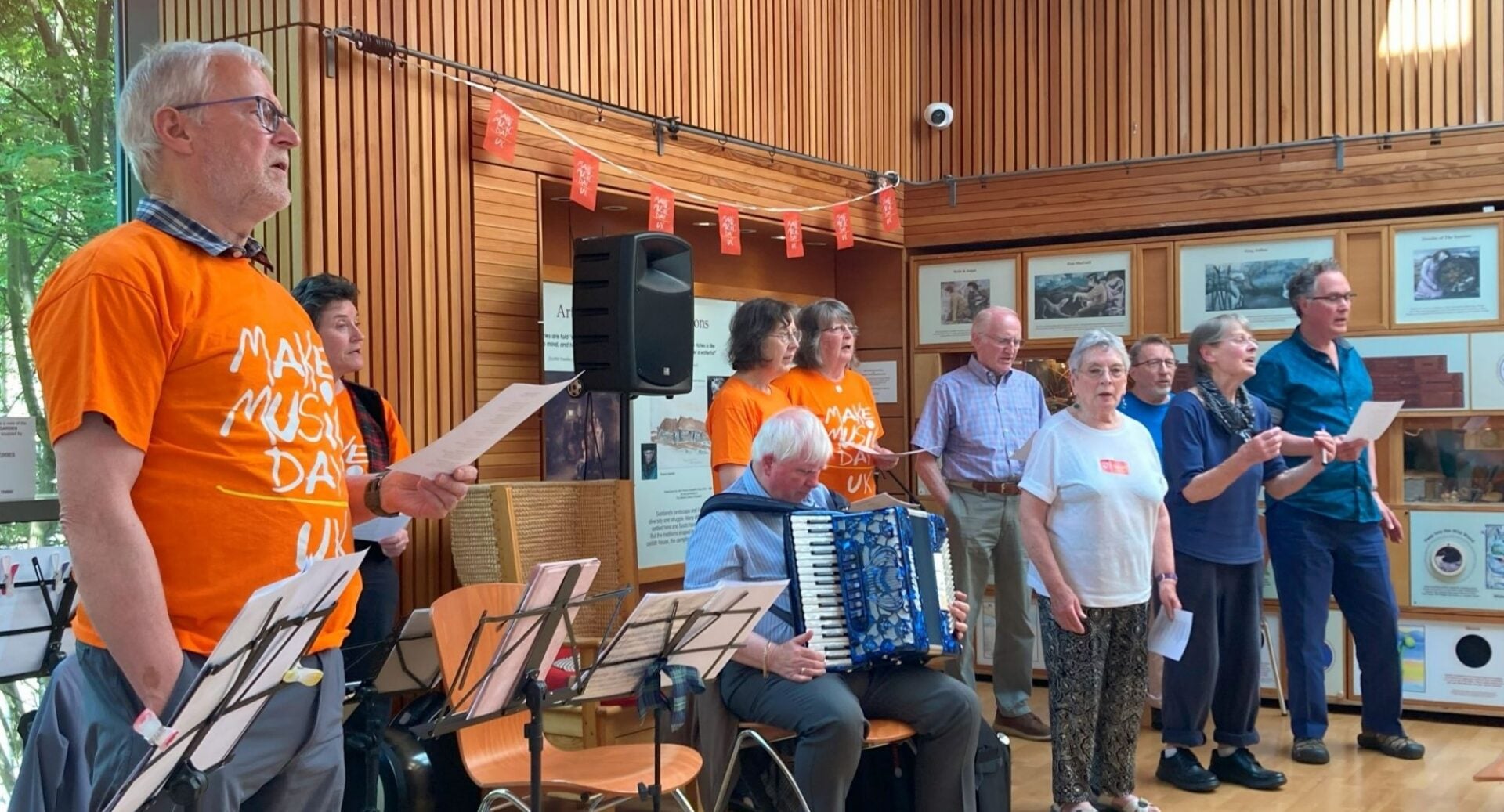 A group of people, including an accordionist, performing on stage.