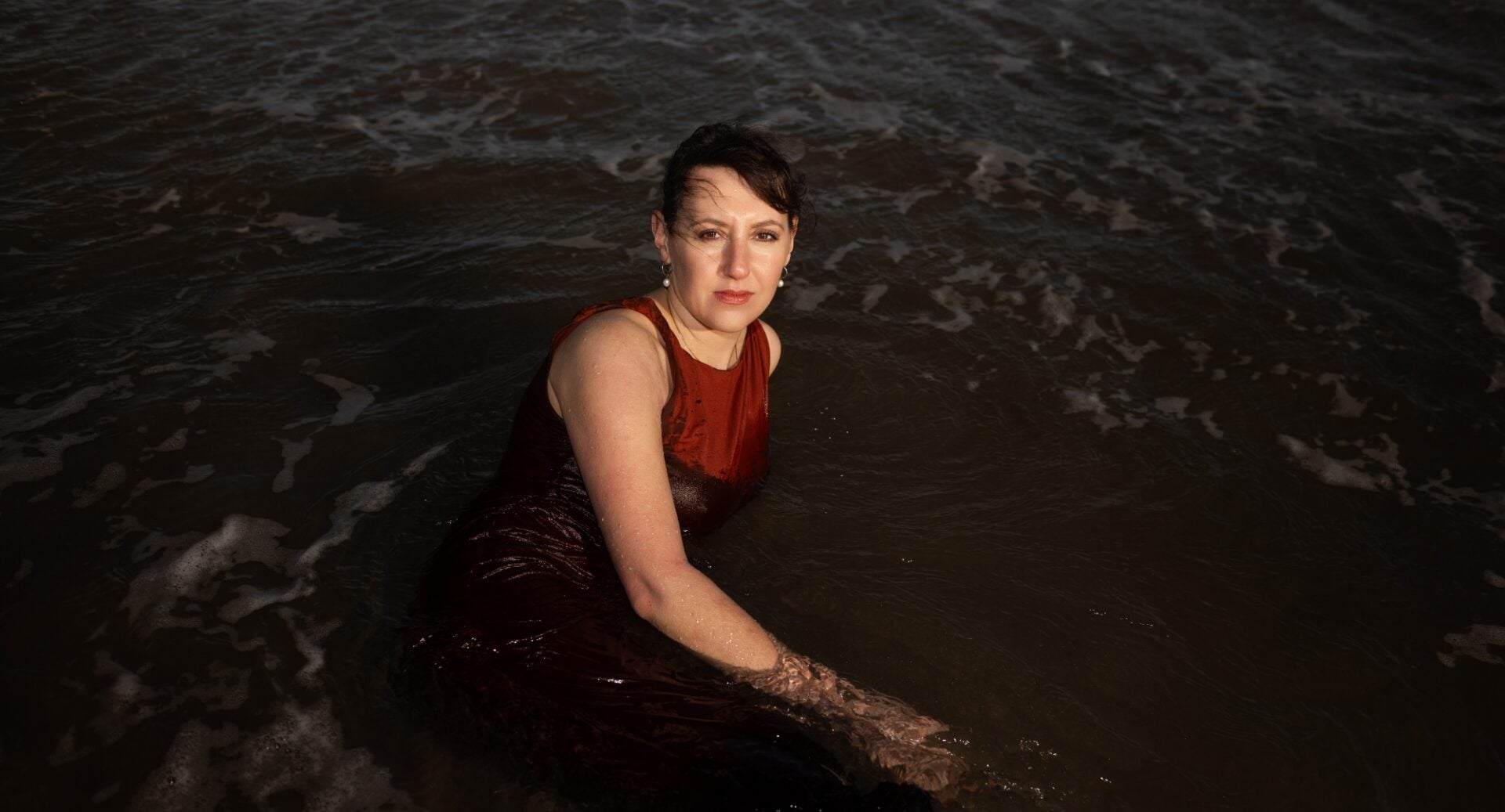 Women lying in a pool of water.