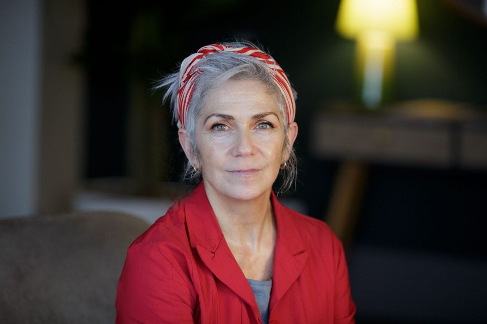 Woman in red jacket and red and cream headband.