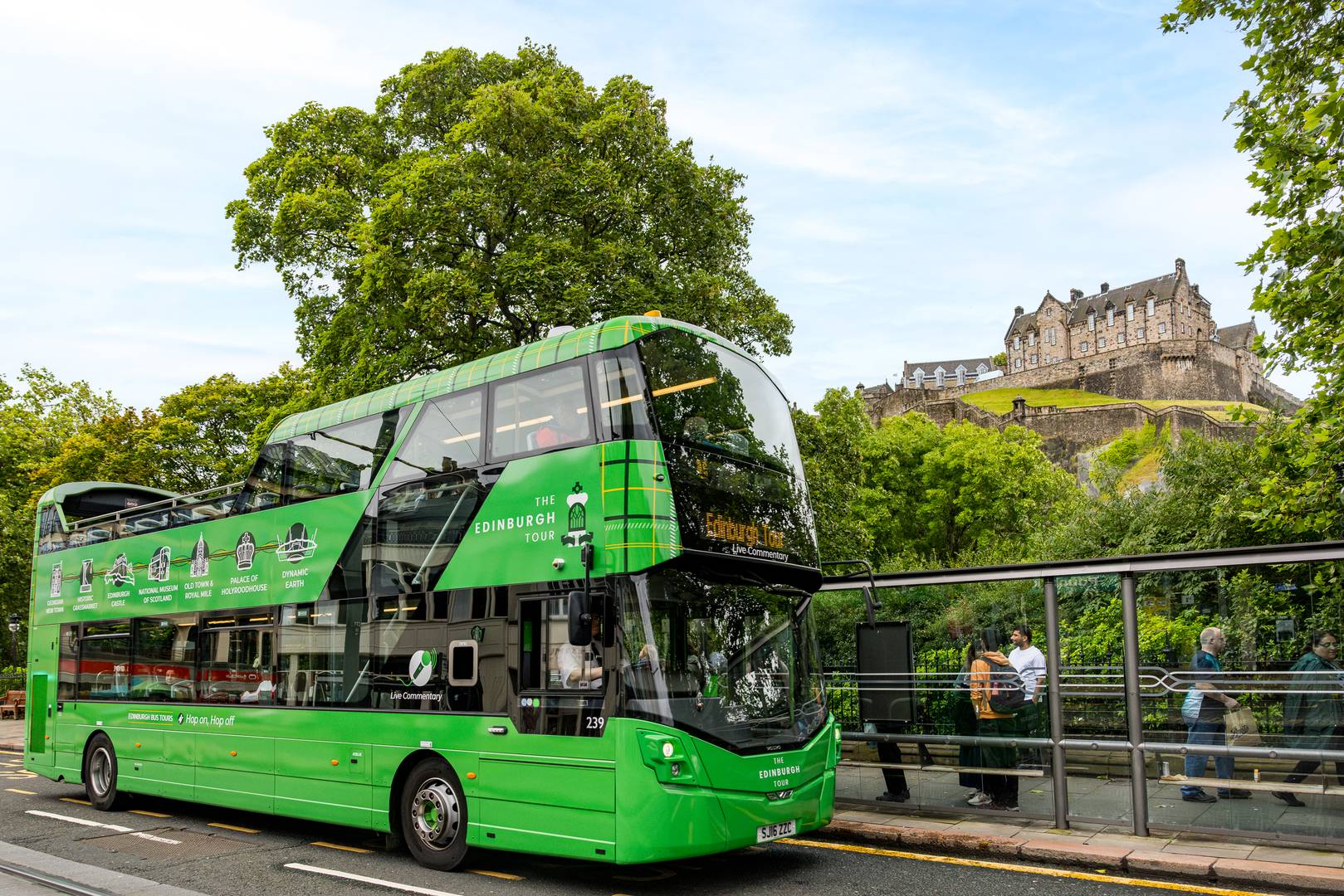 The Edinburgh Tour (green bus) stopped on Princes Street with Edinburgh Castle in the background,© Edinburgh Bus Tours