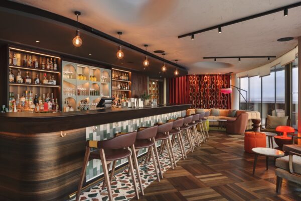 Bar interior, with chairs against the bar, and floor to ceiling windows.