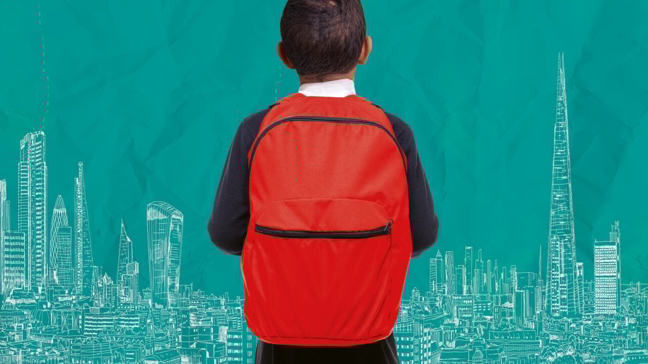 Back view of young boy with a red rucksack on his back.