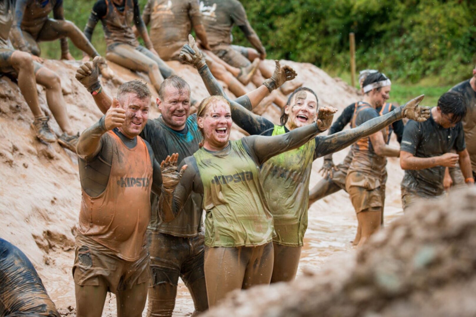 Group of people standing in a muddy ditch.
