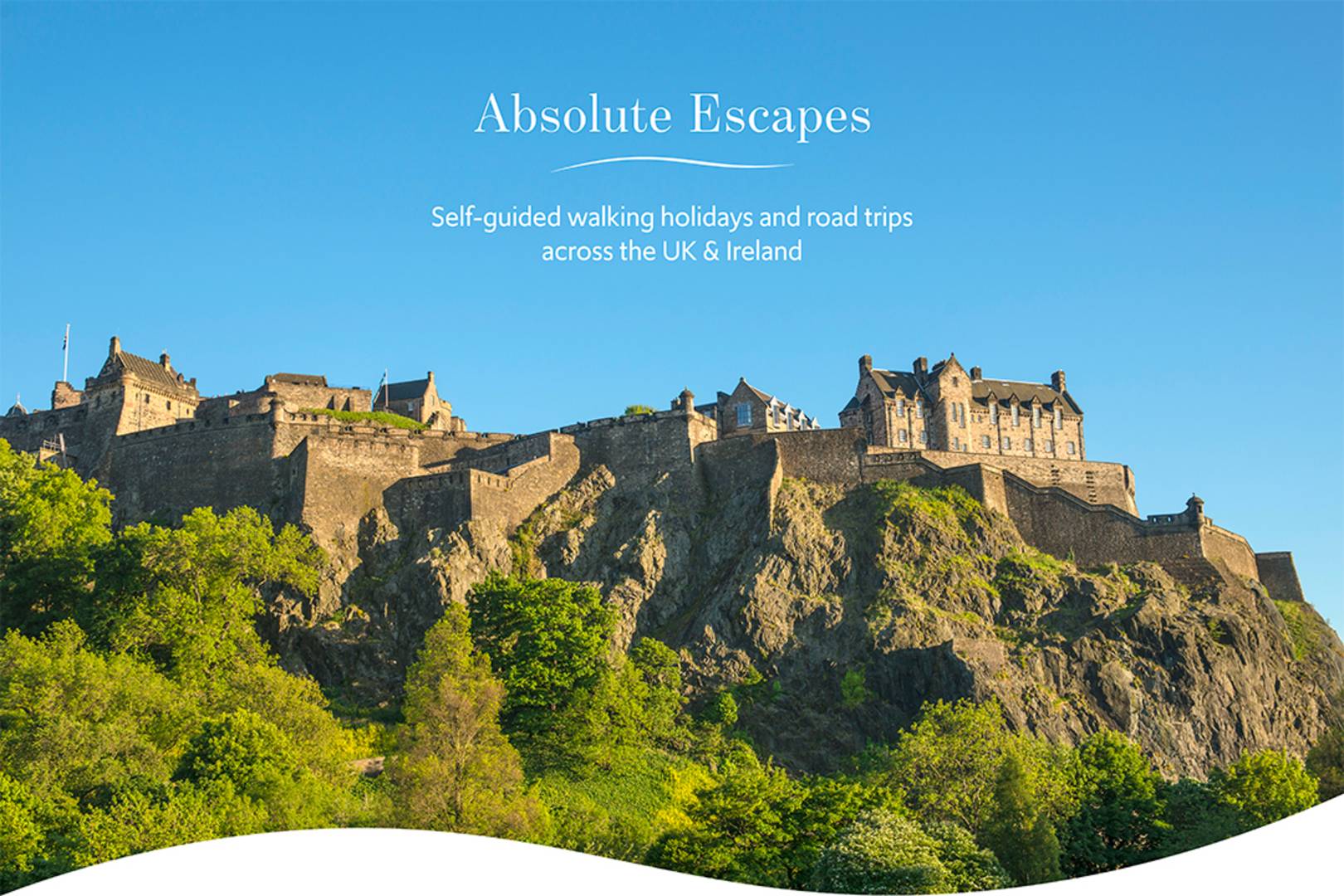 Edinburgh Castle from Princes Street, on a sunny day with blue skies. Text on the image reads: 'Absolute Escapes. Self-guided walking holidays and road trips across the UK & Ireland.',© Visit Scotland, Kenny Lam