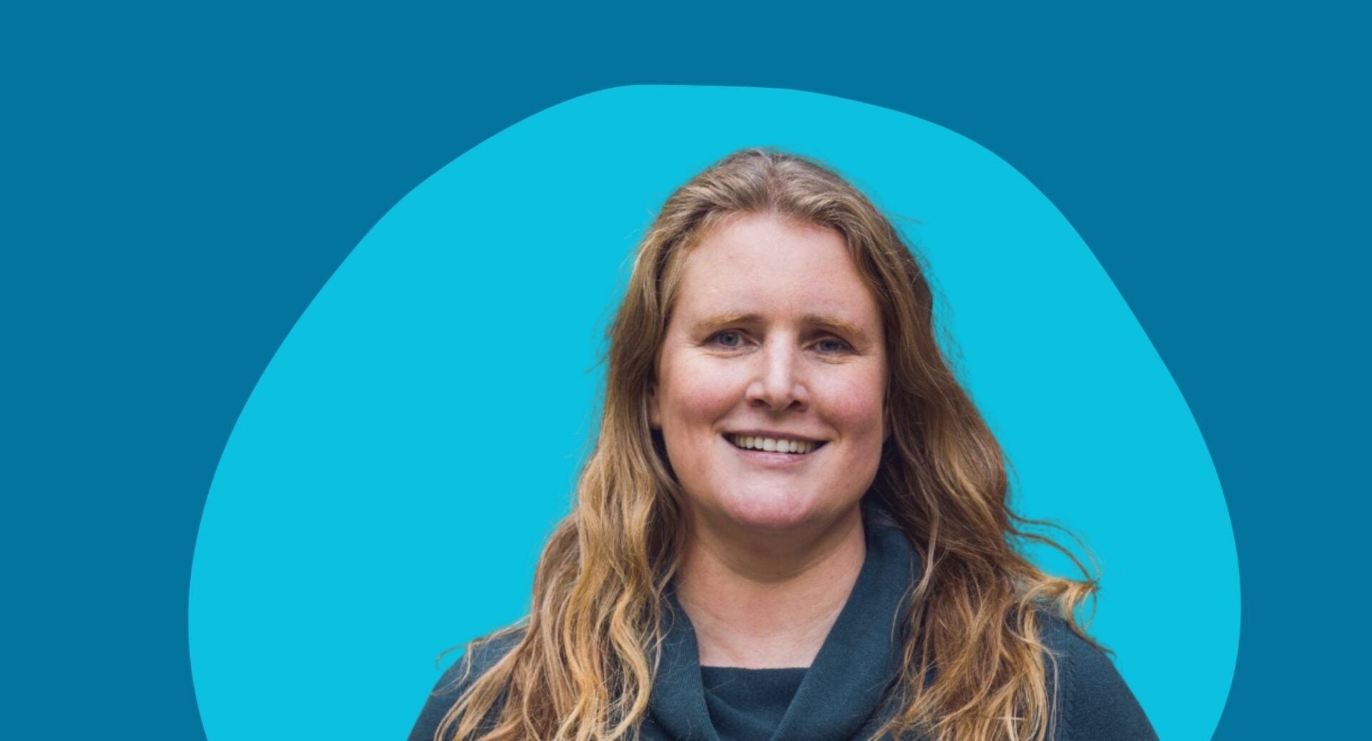 Head and shoulders image of a woman with long blonde hair, standing against a blue background.