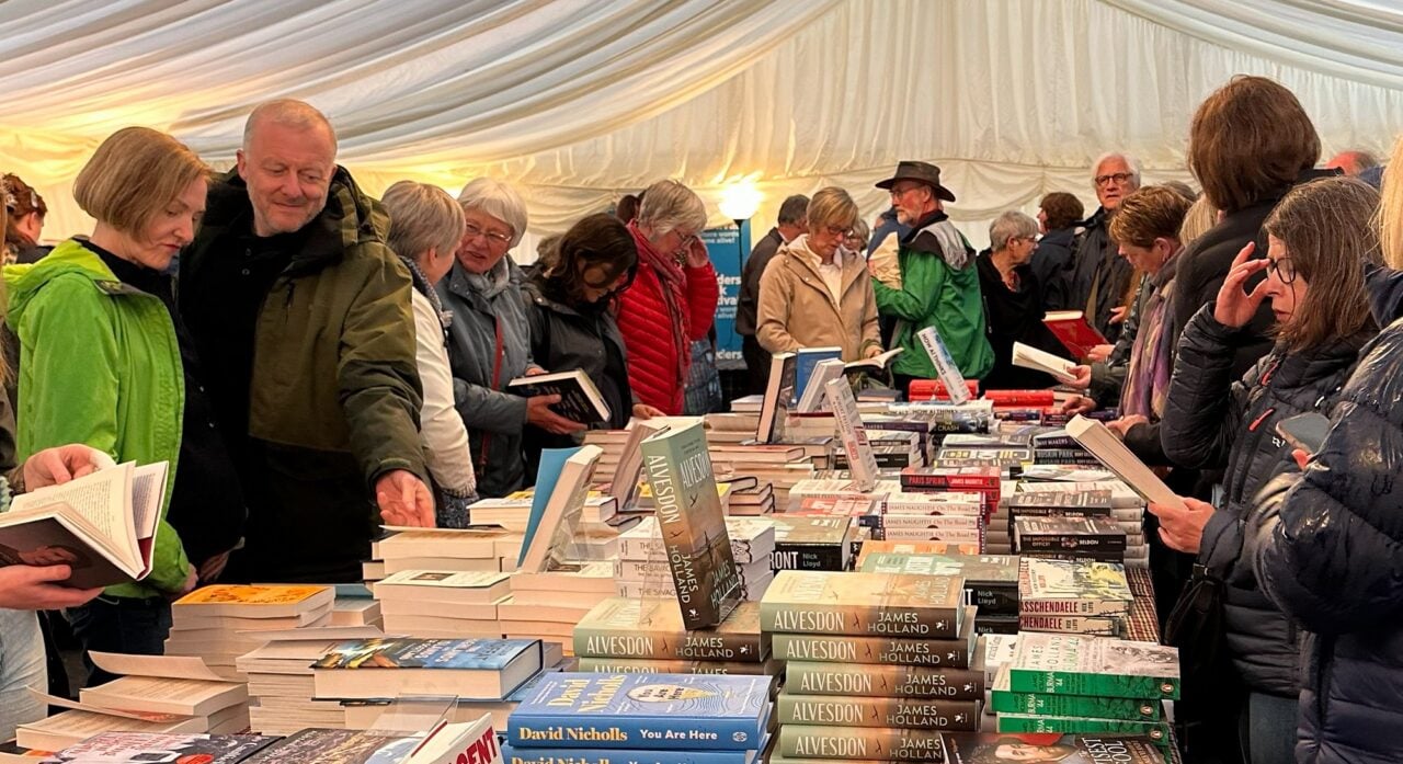 Crowds of people browsing books from a large table.