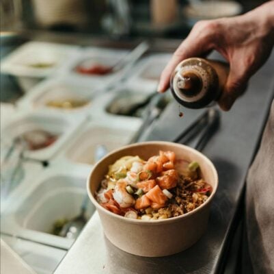 Dressing being poured on salad bowl