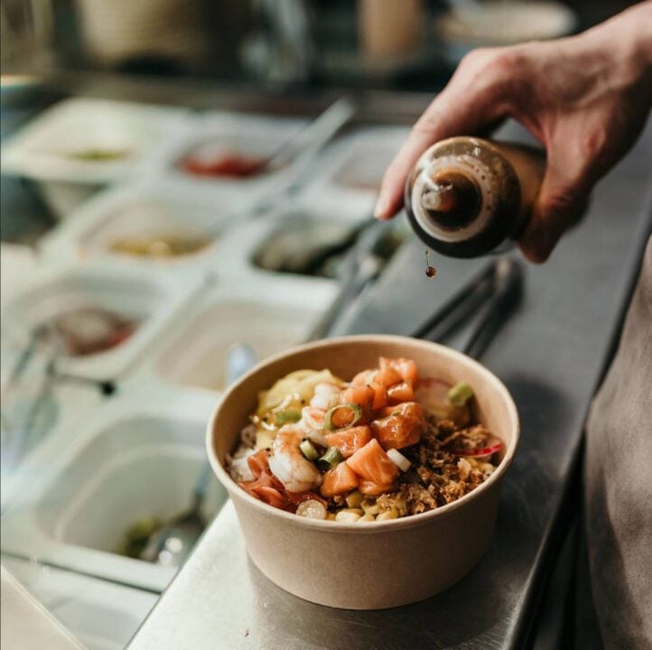Dressing being poured on salad bowl