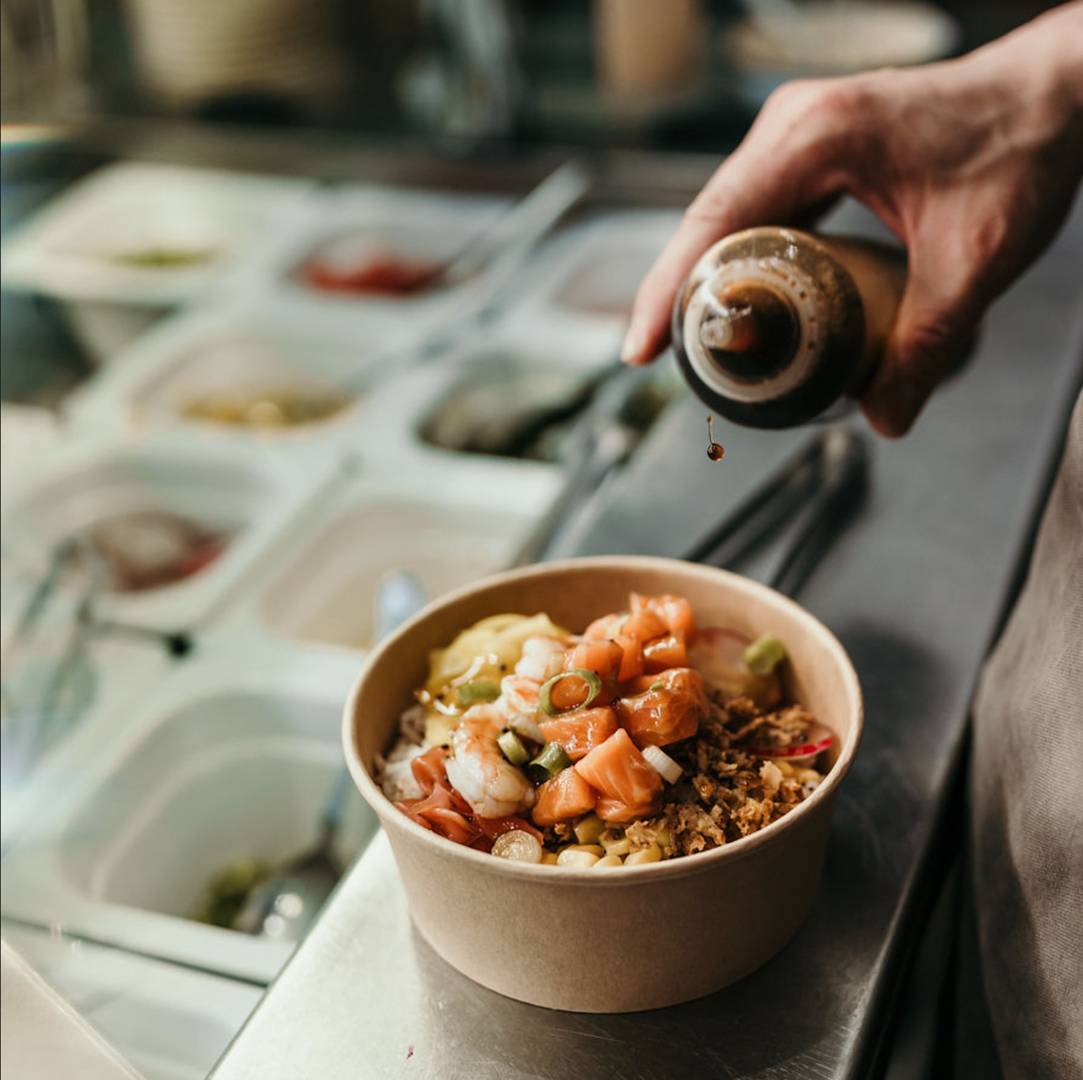 Dressing being poured on salad bowl